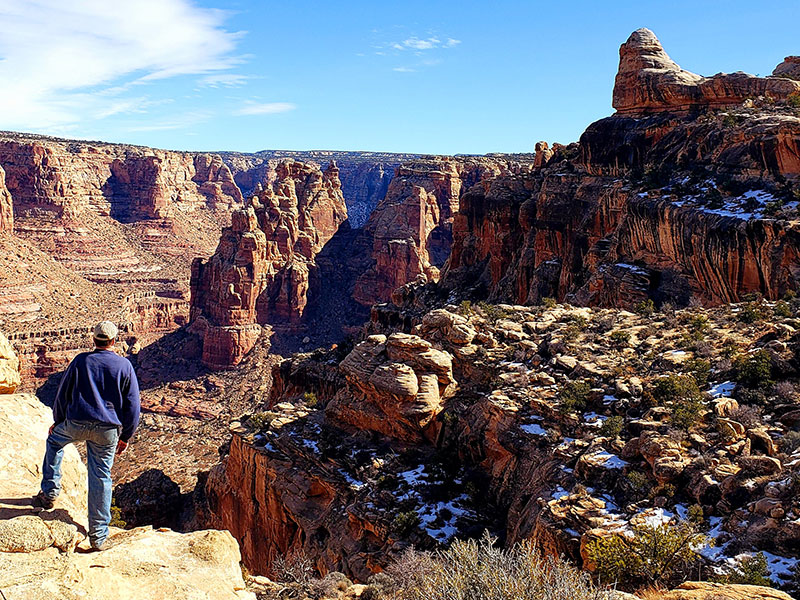 A man looking down the rock formations of Utah