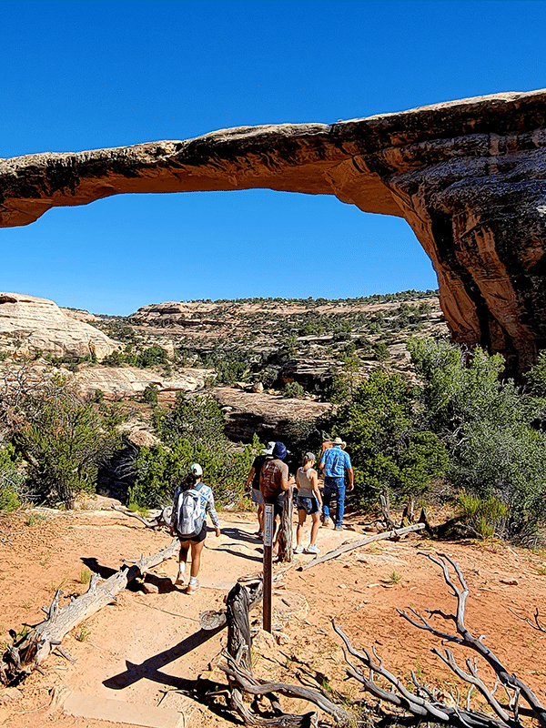 people hiking towards one of the stone bridges